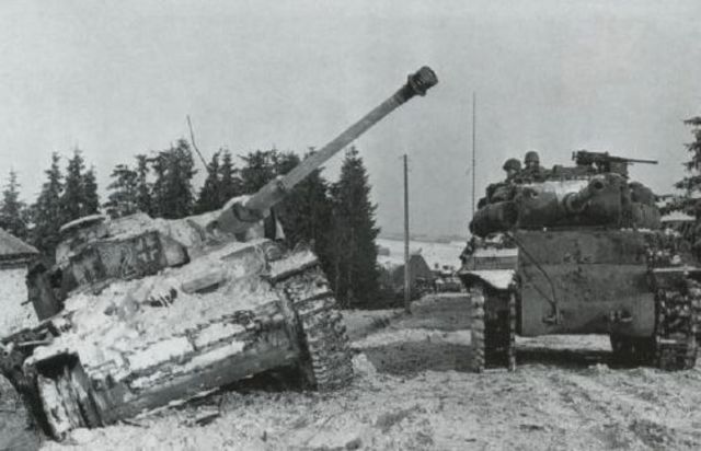 Un cazacarros norteamericano M-36 pasa junto a un Panzer IV abandonado de la 15ª Panzergrenadier Division en la localidad belga de Langlir. 13 de Enero de 1945