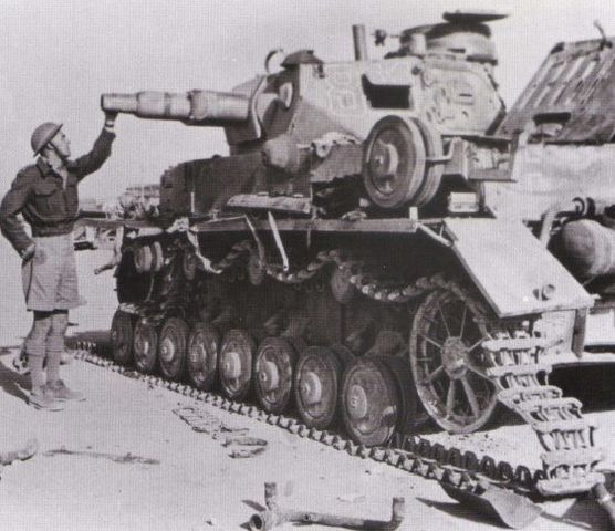 Soldado británico observando un Panzer IV puesto fuera de combate en Tobruk. Mayo de 1941