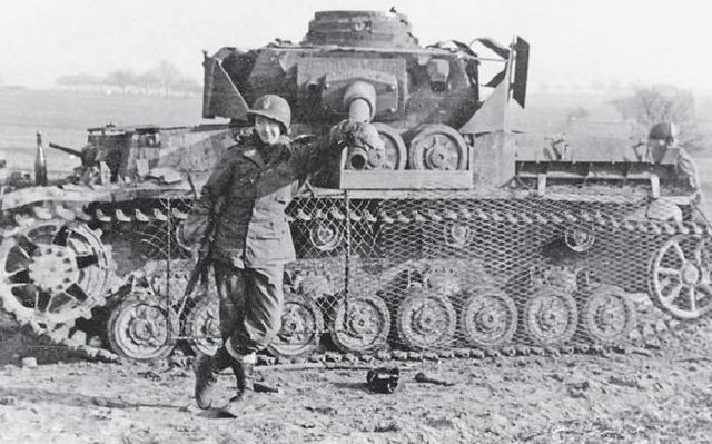 Soldado norteamericano posando junto a un Panzer IV puesto fuera de combate en Alsacia. Enero de 1945