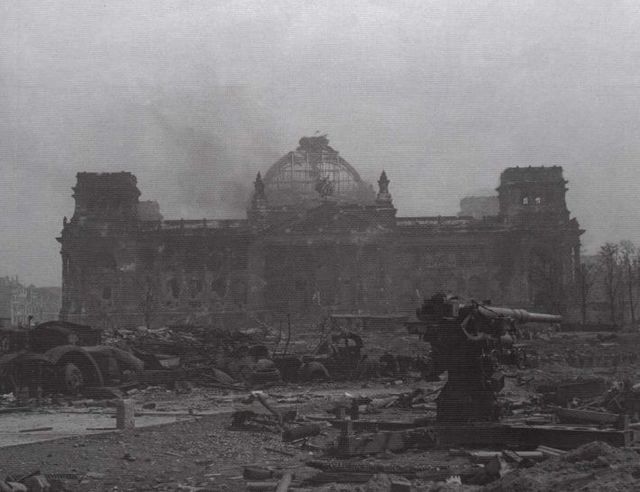 Final de la batalla de Berlín, mayo de 1945. Un Flak de 88 mm puesto fuera de combate. Al fondo el Reichstag en ruinas