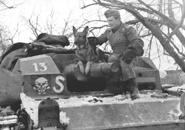 Un miembro de la tripulación y su perro posando en su StuG III Ausf B. Frente Oriental, invierno de 1941-1942