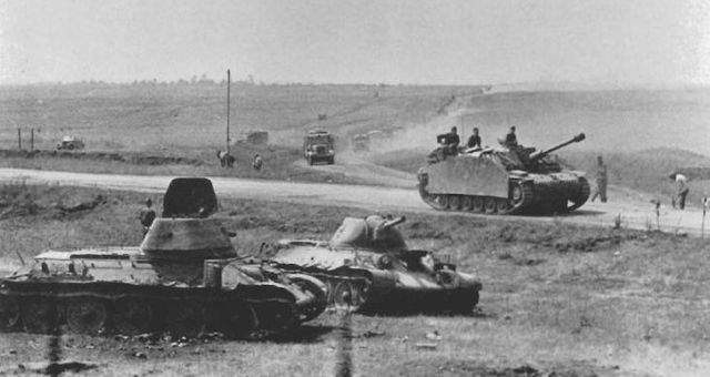 Un StuG III Ausf G, encabezando una columna motorizada. A la izquierda dos T-34 76 soviéticos puestos fuera de combate. Verano de 1942